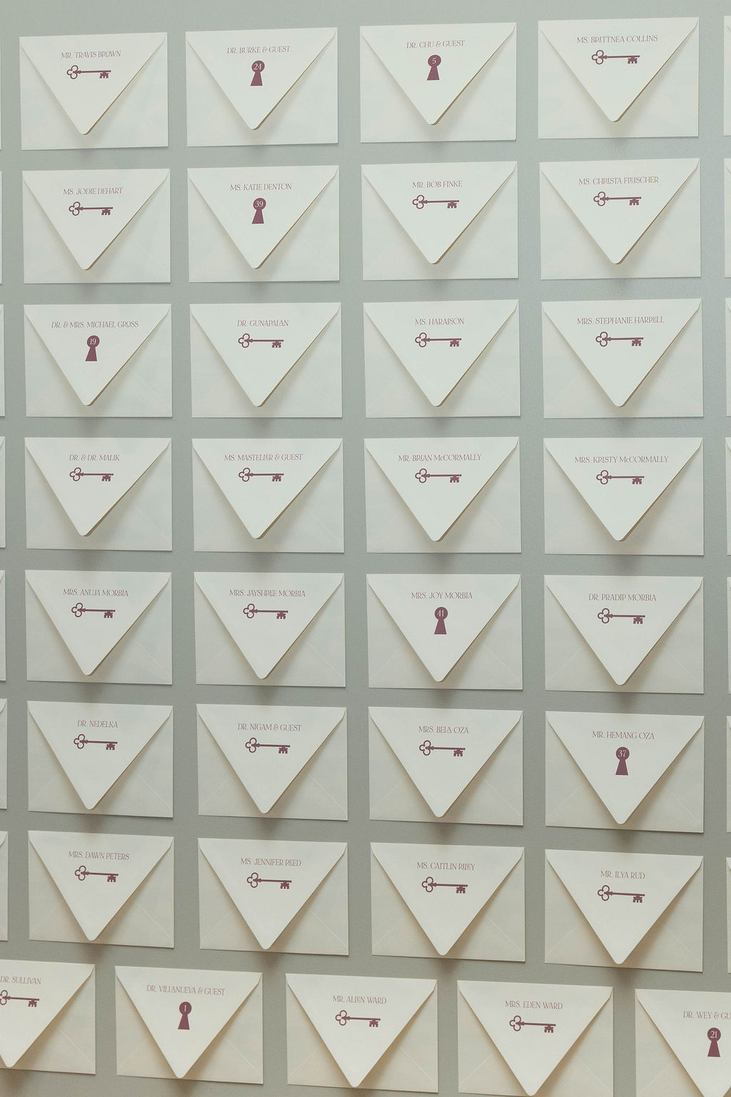Custom envelope wall installation featuring personalized guest envelopes and hidden experience cards at a Virginia Beach corporate grand opening event designed by Lustre Theory.
