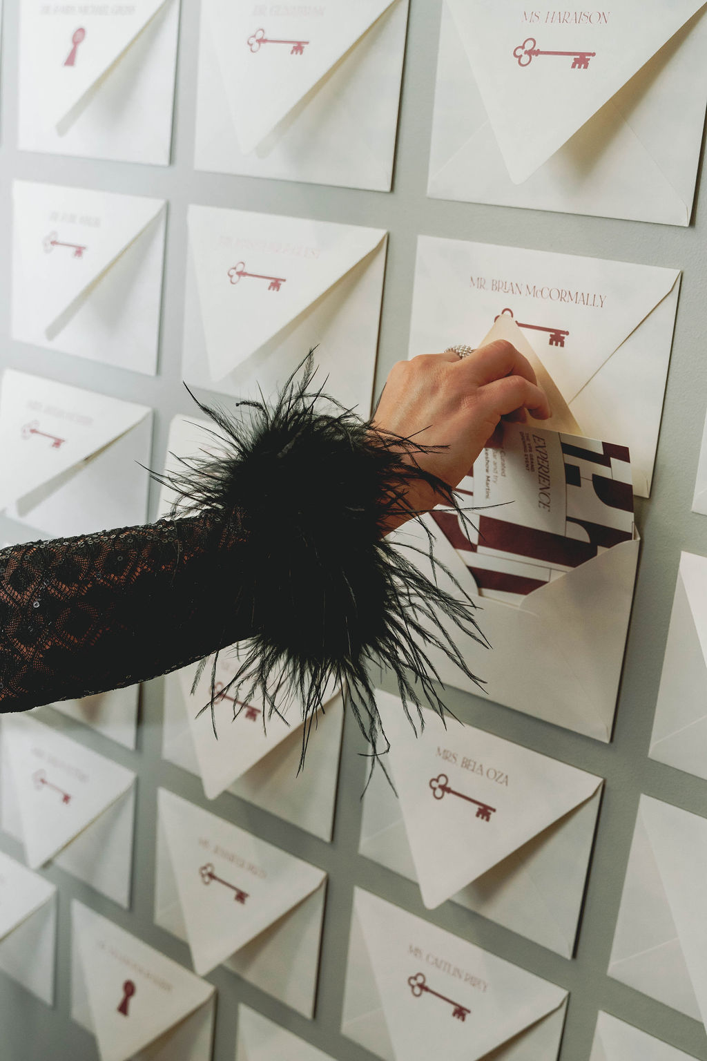 Guest retrieving a custom experience card from a personalized envelope wall installation at a Virginia Beach corporate event designed by Lustre Theory.