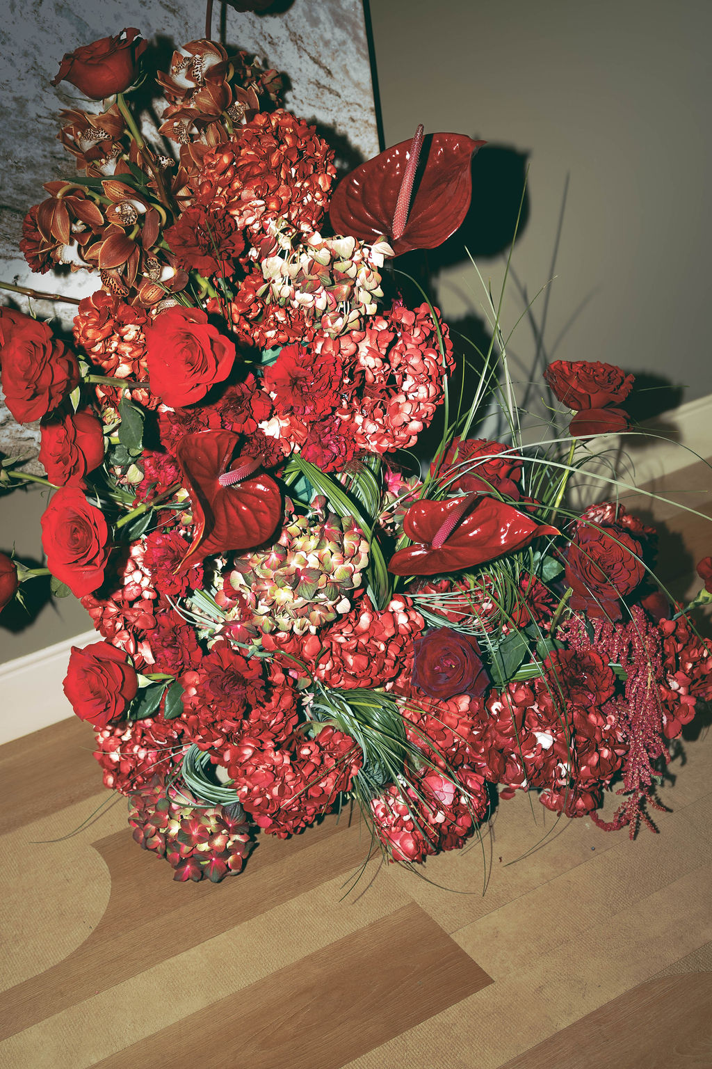 Custom floral installation featuring red roses, hydrangeas, orchids, and anthuriums designed for a Virginia Beach grand opening event with luxury event design and production by Lustre Theory.