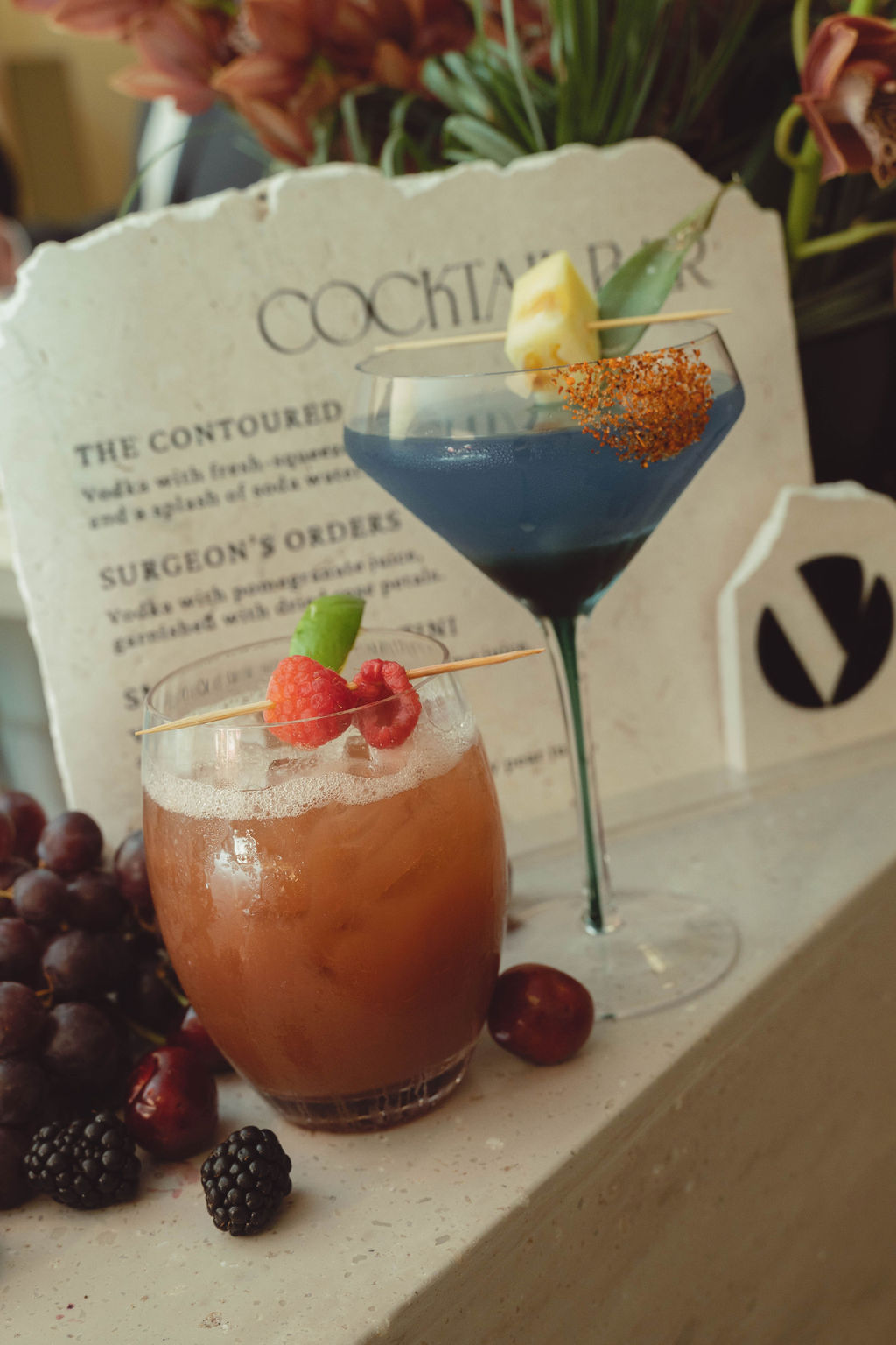 Custom signature cocktails displayed at a branded cocktail bar during a Virginia Beach grand opening event featuring luxury event design, specialty beverage experiences, and production by Lustre Theory.